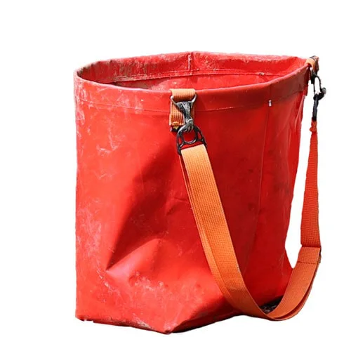 Eine robuste rote Pflanztasche mit einem orangefarbenen Schultergurt, ideal zum Transport von Setzlingen bei Wiederaufforstungsarbeiten.